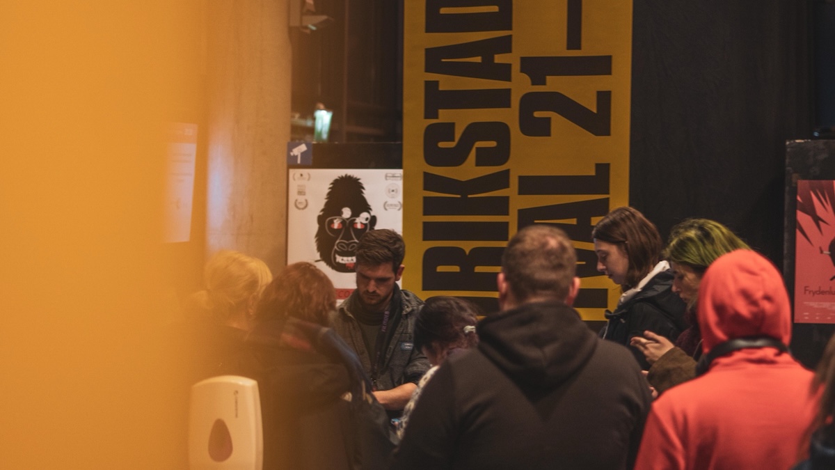 Jonas Saabel at the guest desk during Fredrikstad Animation Festival, surrounded by festival guests